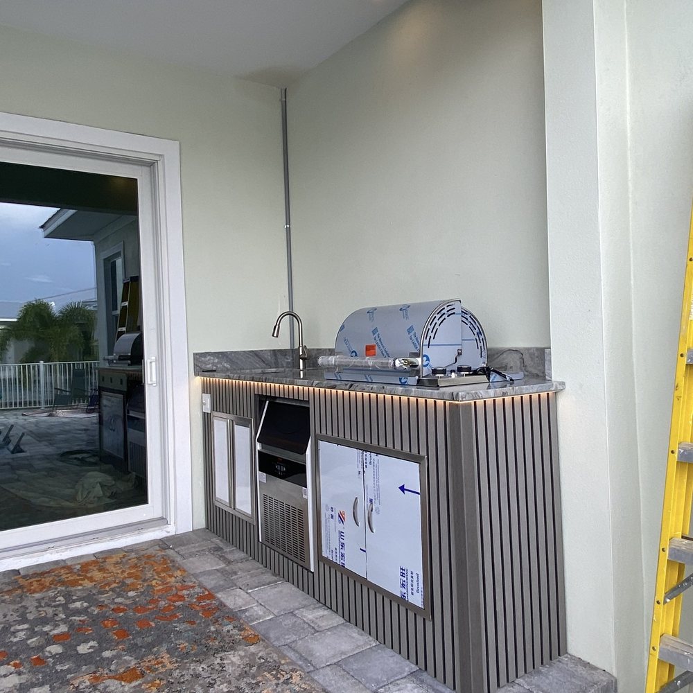 Outdoor kitchen build with grill, sink and stone countertop